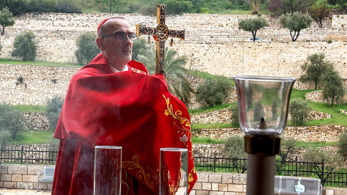Cardinal Pierbattista Pizzaballa, the Latin Patriarch of Jerusalem, holds a cross on Palm Sunday