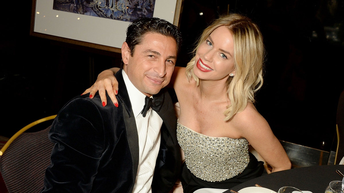 Cem Habib and Caroline Stanbury standing together at a gala dinner.