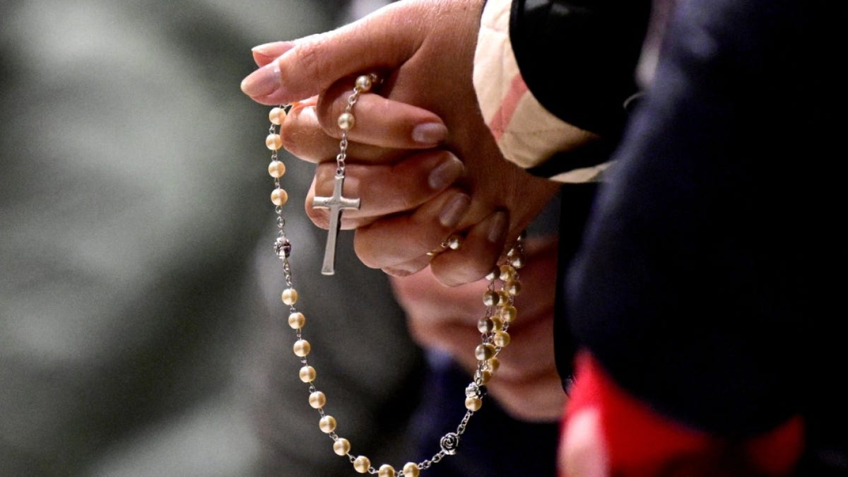 A woman holds a rosary during a holy mass and prayers for the healing of Pope Francis at Saint John Lateran archbasilica in Rome, on February 23, 2025.