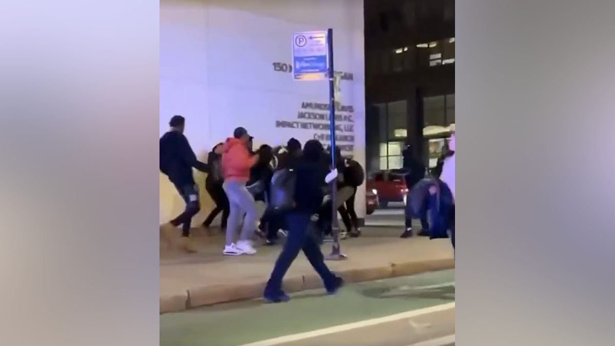 Teens fighting on sidewalk during chaotic gathering in downtown Chicago Loop