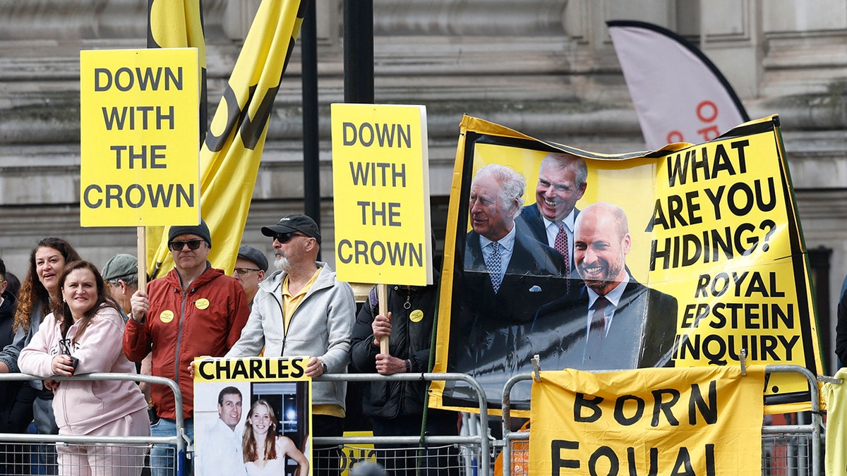 Protest signs that say Down with the crown and What are you hiding?