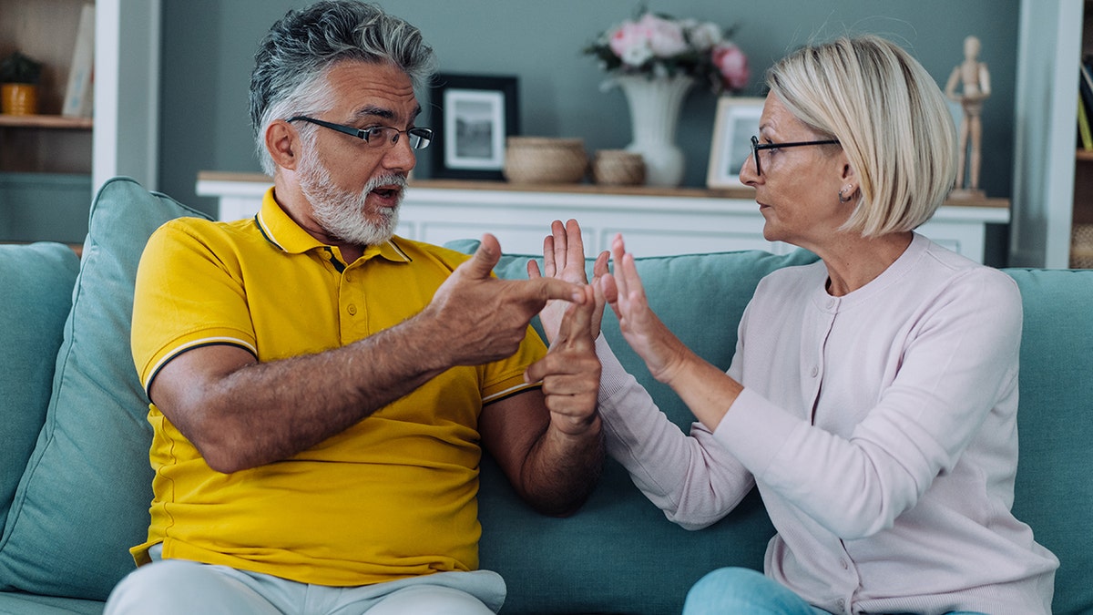 older couple argue on the couch
