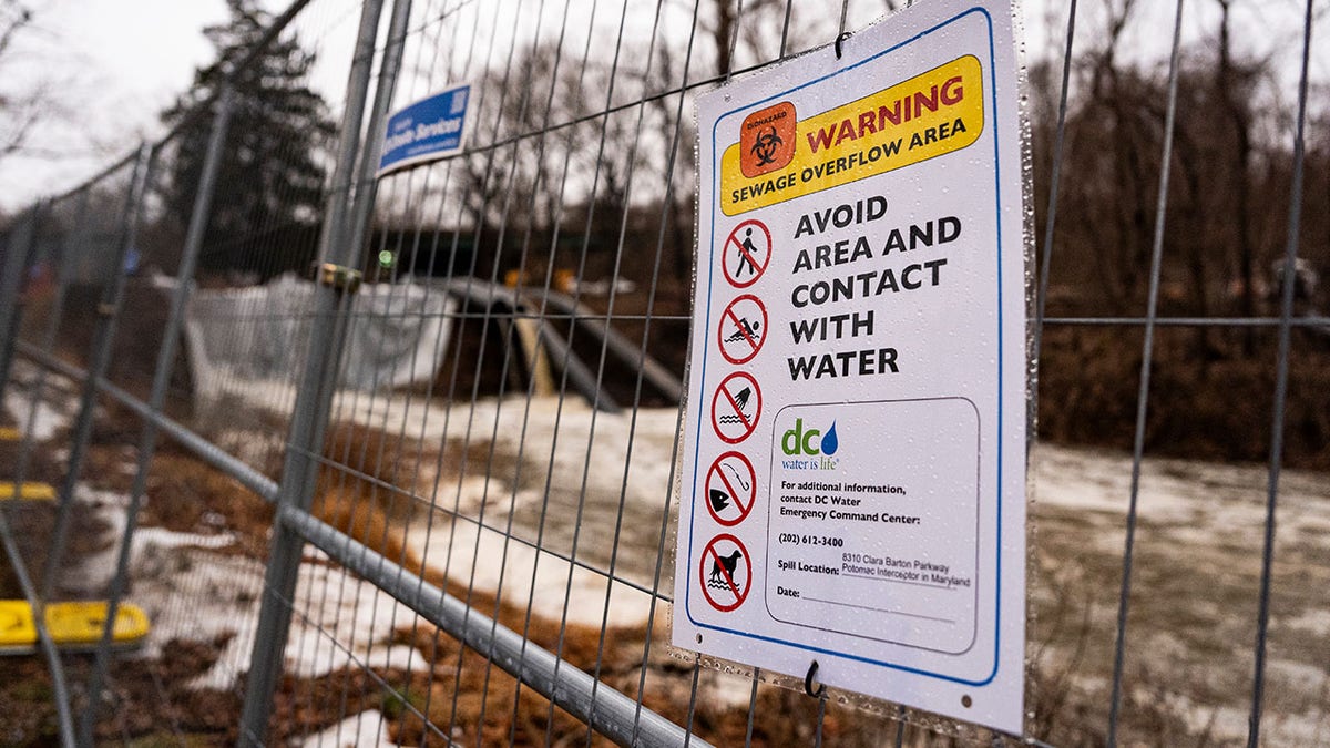 A DC Water sign instructing pedestrians to avoid the area near the C&O Canal, which is being used to redirect sewage water around a broken section of the Potomac Interceptor, a six-foot-wide sewage pipe between the Clara Barton Parkway and the C&O Canal, in Cabin John, Maryland, US, on Friday, Feb. 20, 2026.
