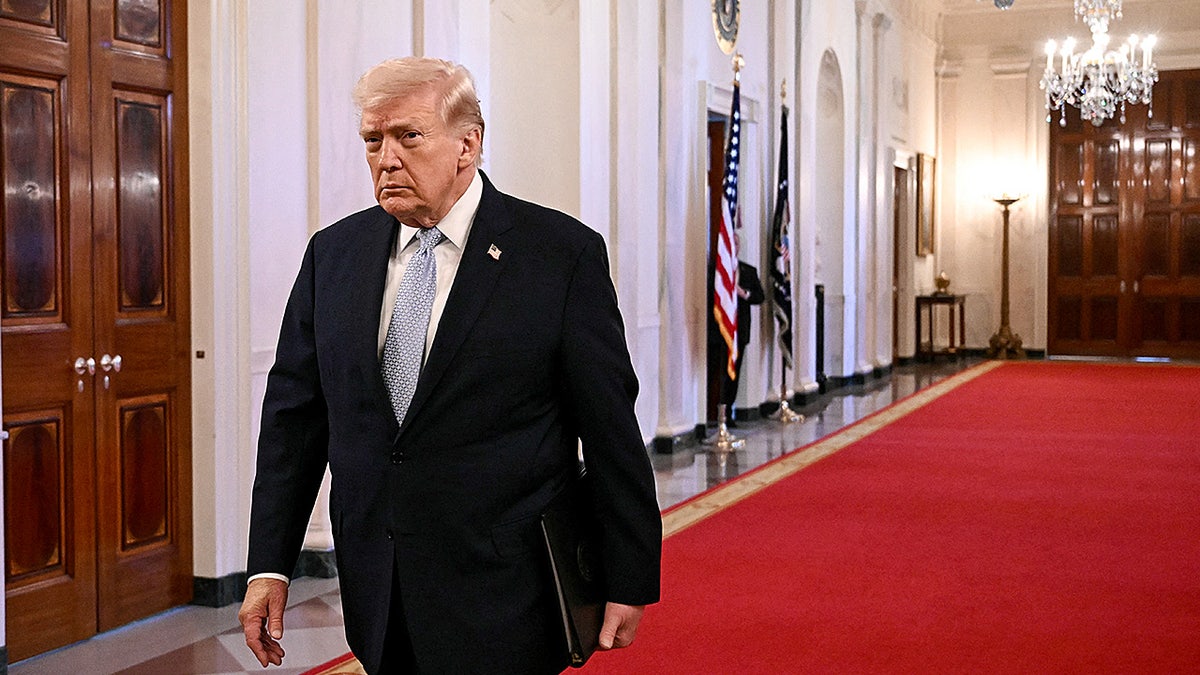 Donald Trump walking through the Cross Hall of the White House.