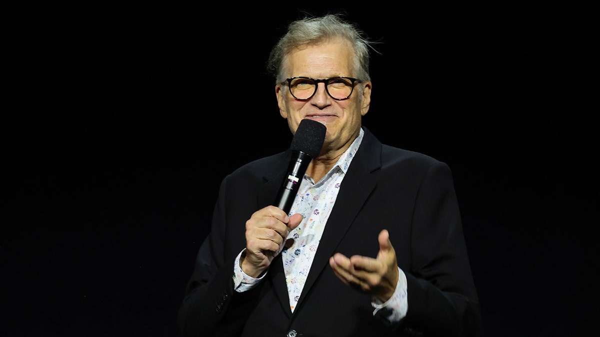 Drew Carey holding a microphone