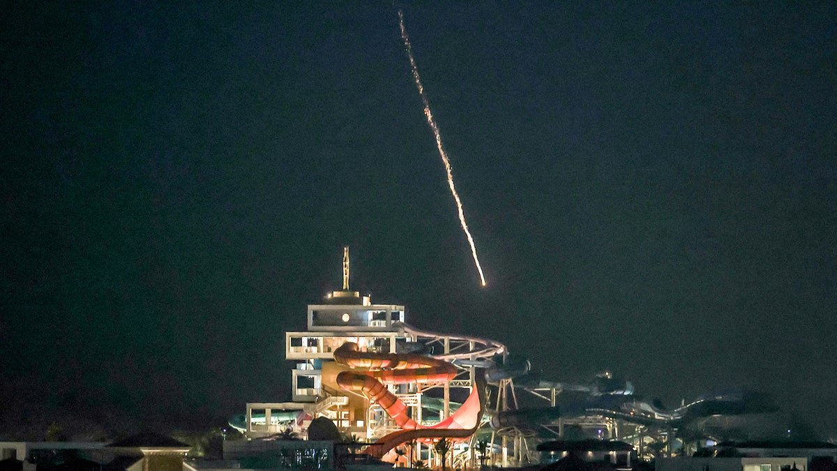 An intercepted projectile falls into the sea near Dubai's Palm Jumeirah archipelago night