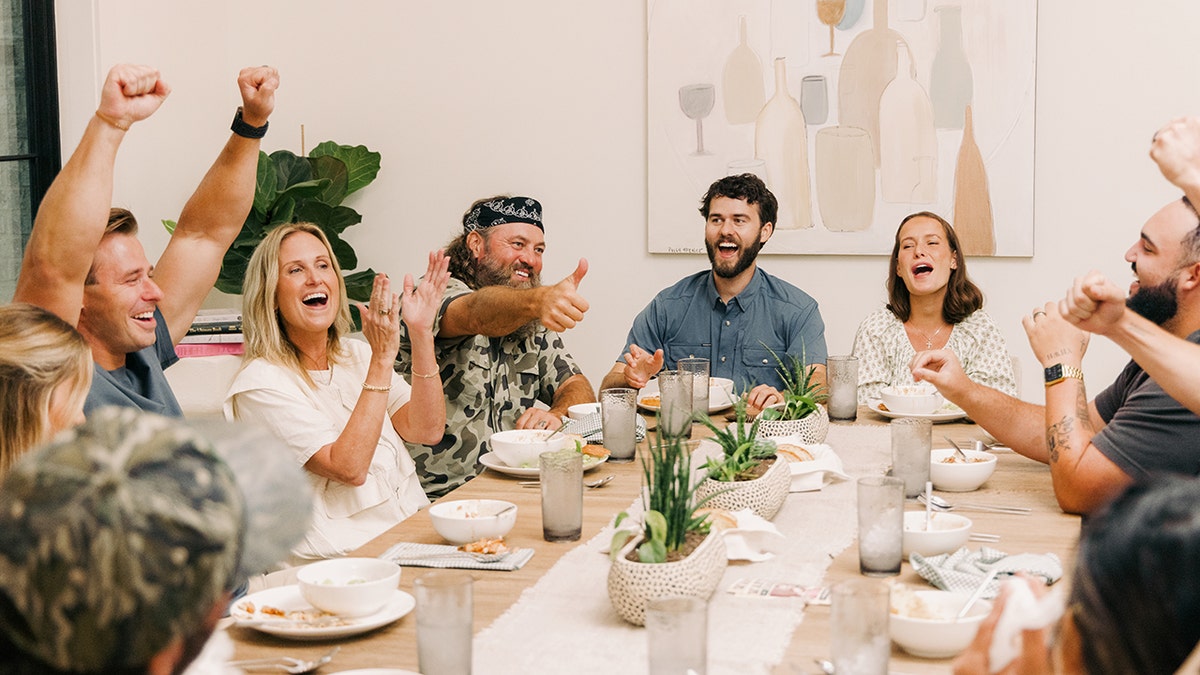 The Robertson family sits around a dinner table during season two of 