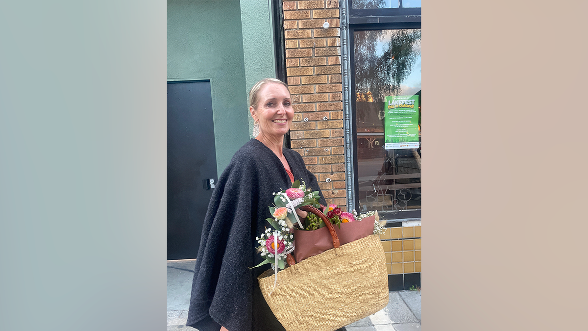 Missing coffee shop owner Amy Hillyard holding flowers outside a building