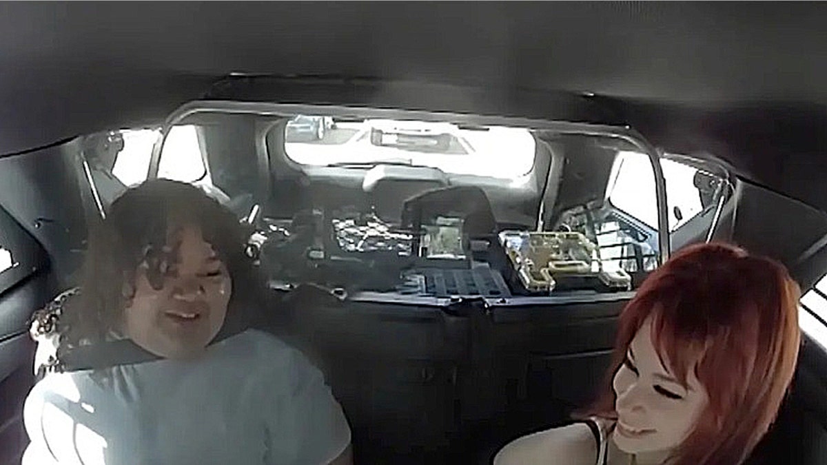 Isabelle Valdez and Lois Lippert laughing in back of patrol car after arrest in alleged Lake Brantley High School plot