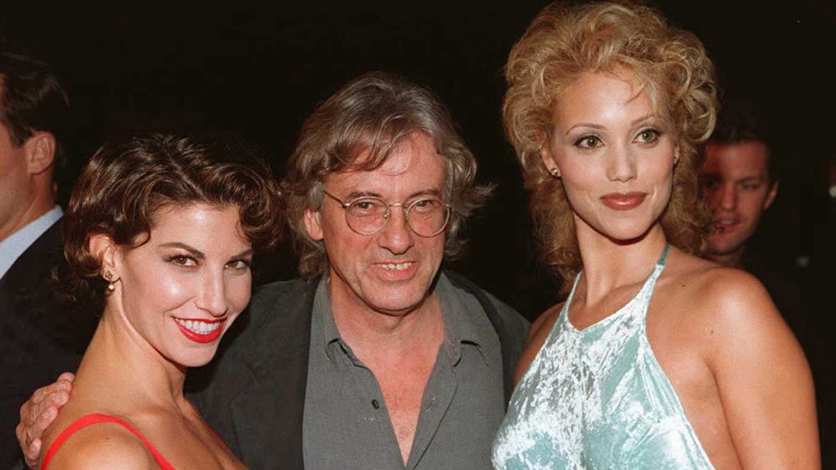 Paul Verhoeven sorrindo com Gina Gershon e Elizabeth Berkley na estreia de "Showgirls."