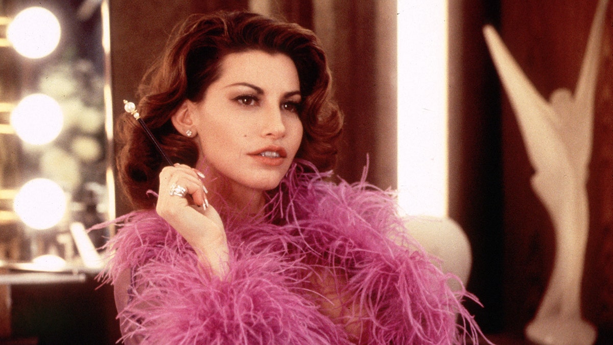 Gina Gershon wearing a pink boa in a scene from "Showgirls."