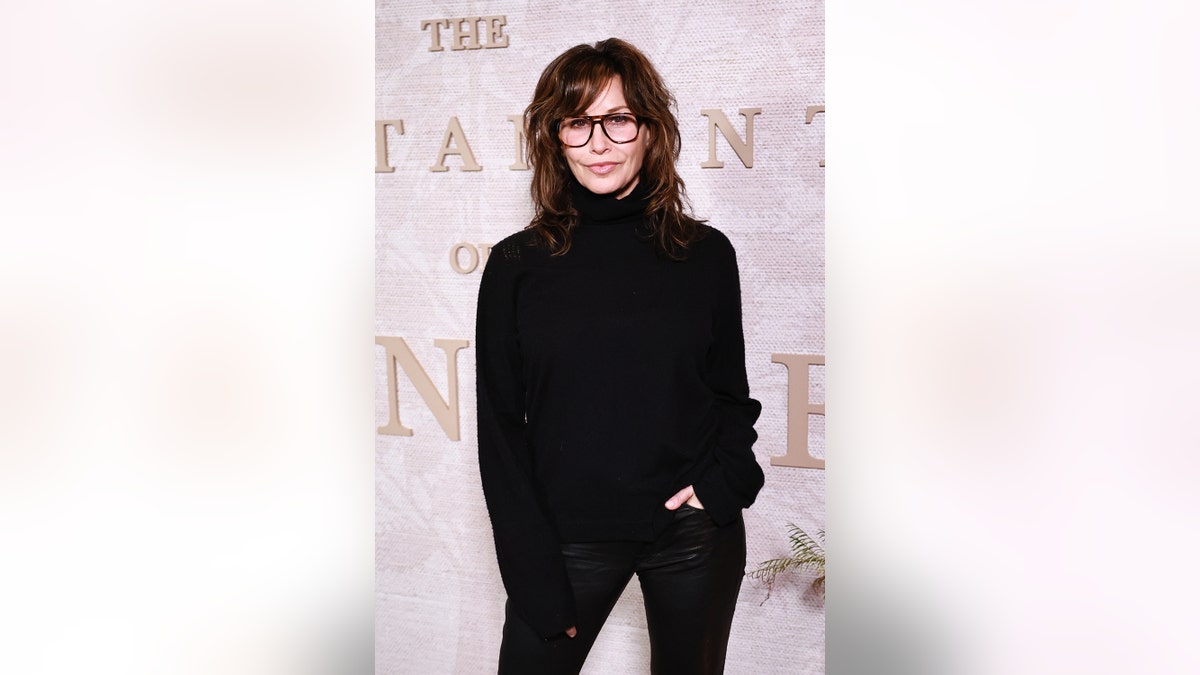 Gina Gershon wearing all black and smiling in New York City.