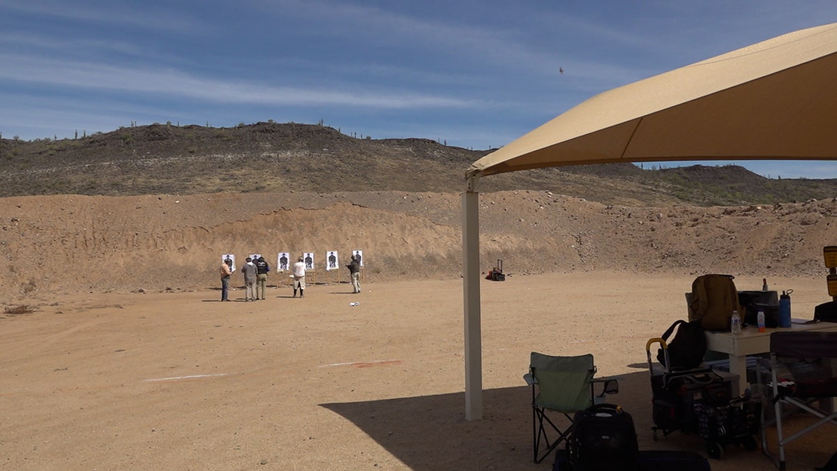 A small group of volunteers stand on a gun range