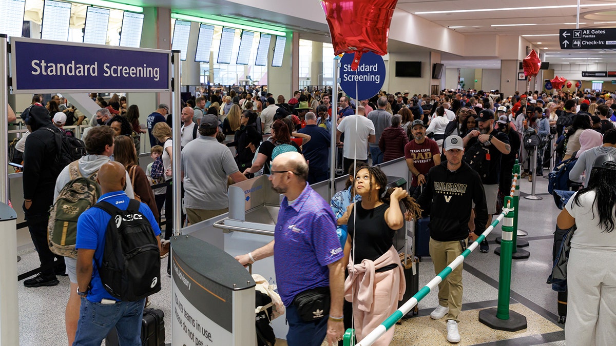 Travelers wait in line at a Transportation Security Administration (TSA) checkpoint at William P. Hobby Airport in Houston, Texas, US, on Monday, March 9, 2026. Airports in the US are reporting longer-than-normal wait times in security lines, as Transportation Security Administration agents are poised to miss their first full paycheck this week. Photographer: Mark Felix/Bloomberg via Getty Images