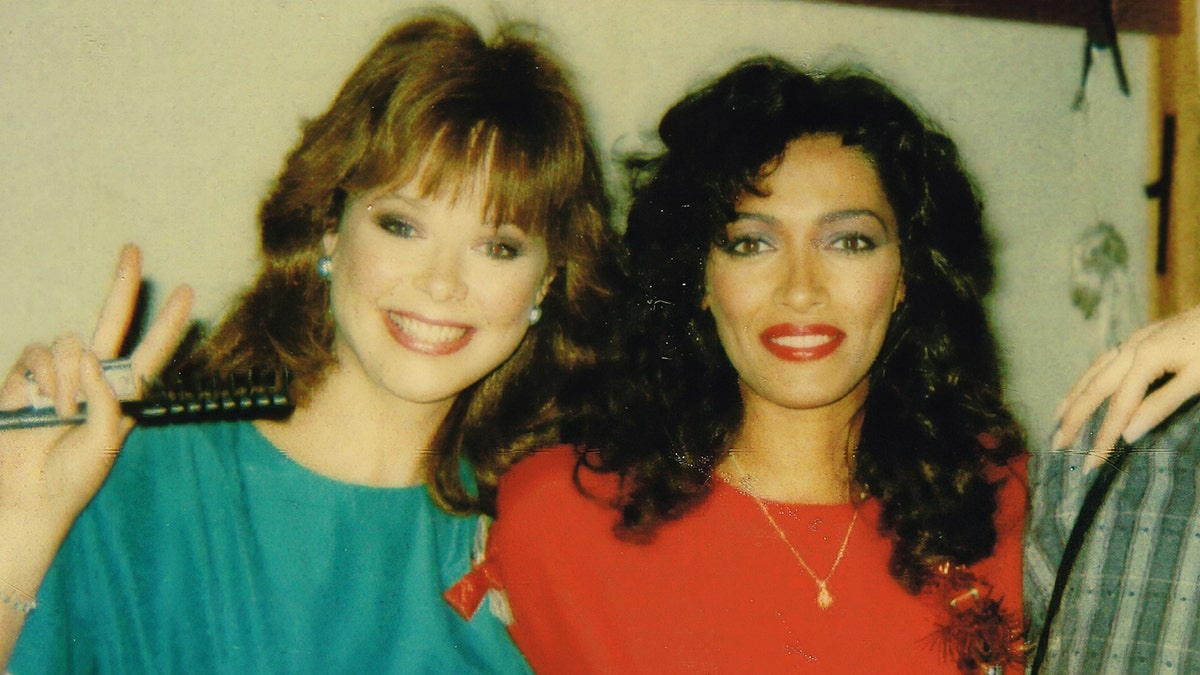 Holly Hallstrom and Kathleen Bradly posing together in green and red sweaters.