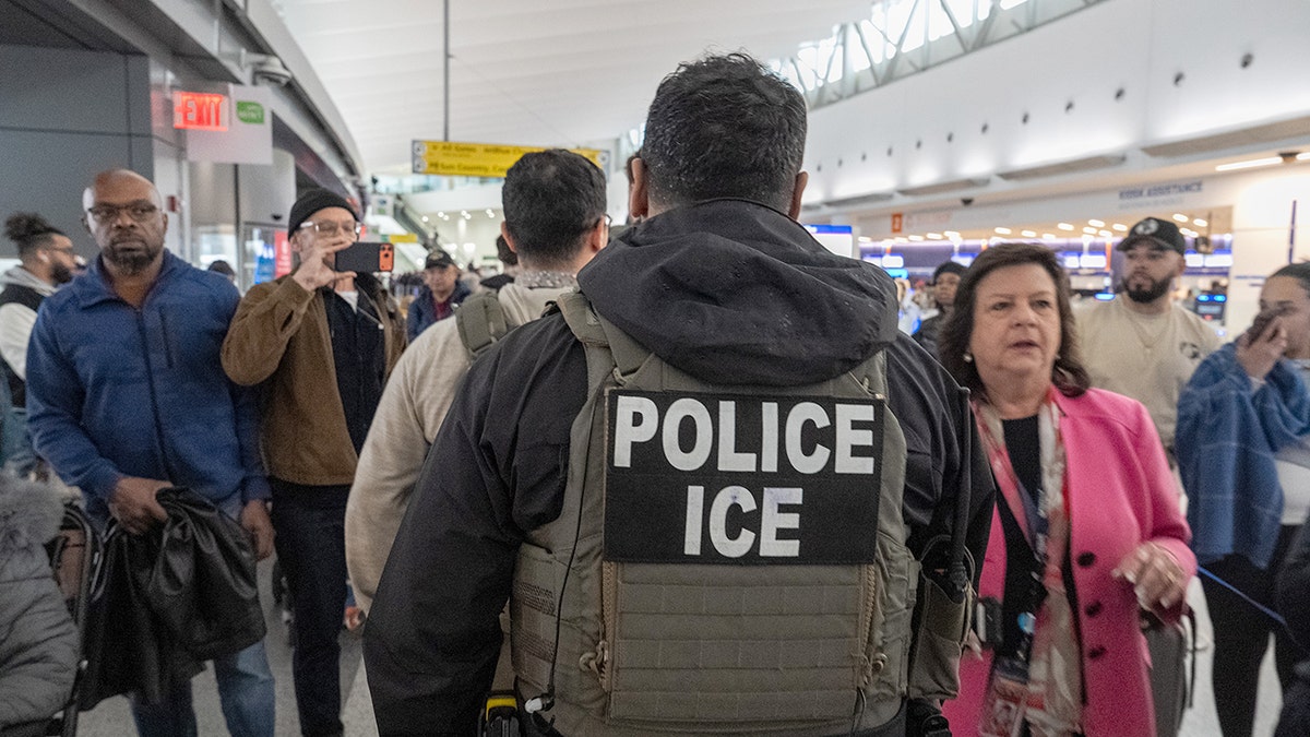 ICE agents walking through a terminal at JFK Airport.