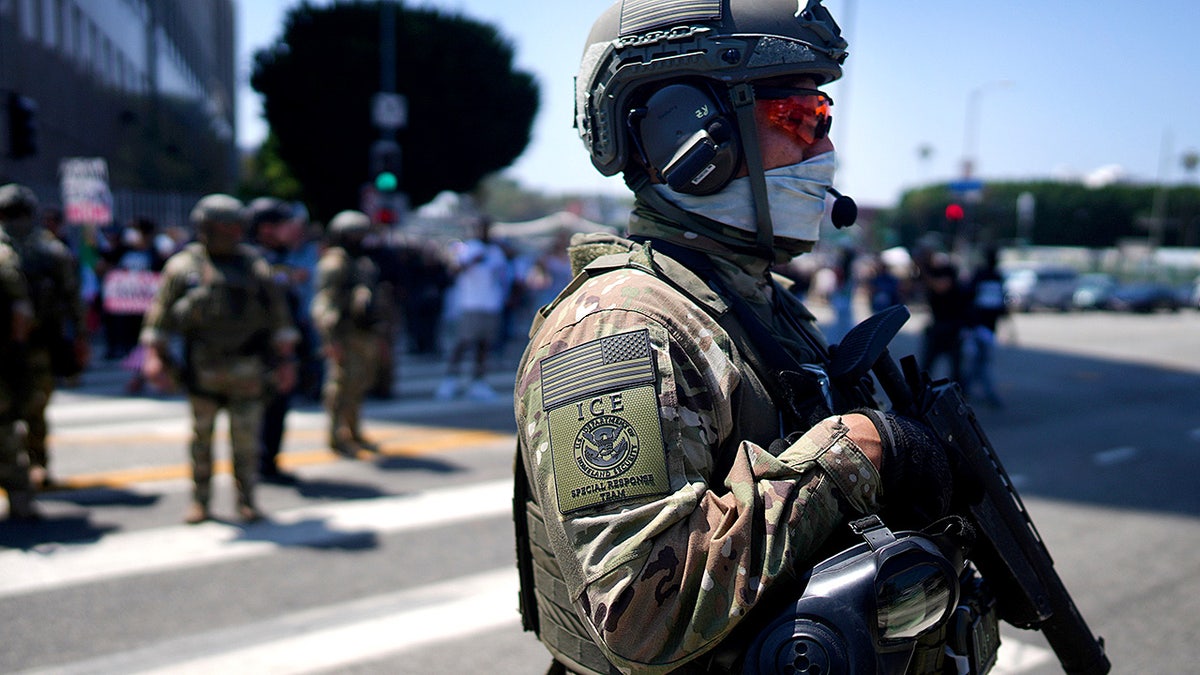 ICE officer stands guard outside detention center in Los Angeles.