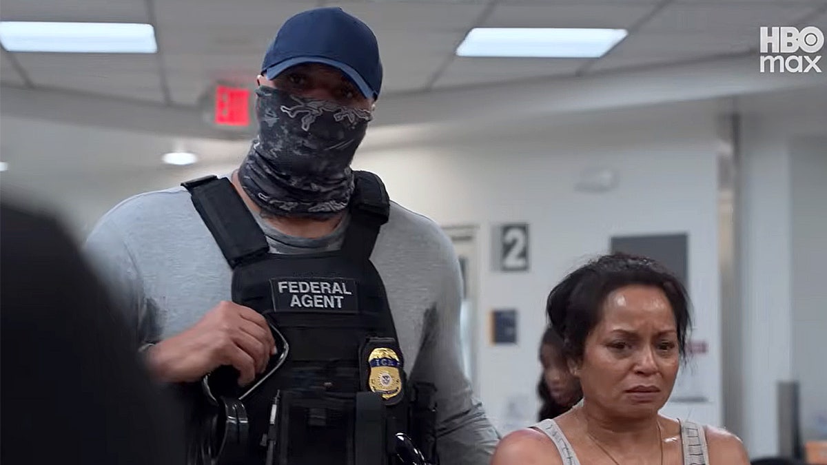 A federal immigration agent bring detained woman for care in