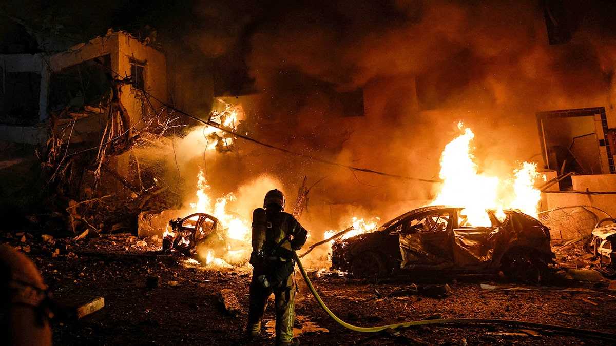 Israeli firefighter puts out flames following strike in Tel Aviv