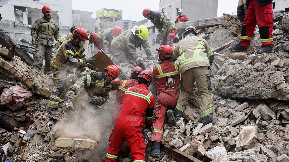 Rescue workers searching through rubble in southern Tehran after a strike