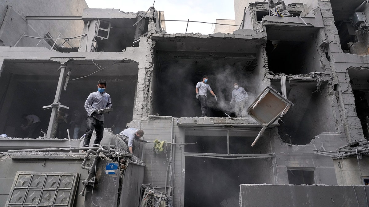 Volunteers cleaning debris from a damaged residential building in Tehran.