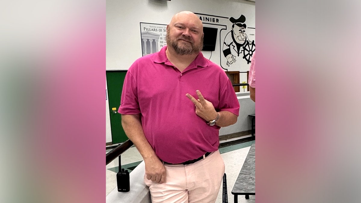 Former principal Jeremy P. Williams poses for a photo, holding up a peace sign.