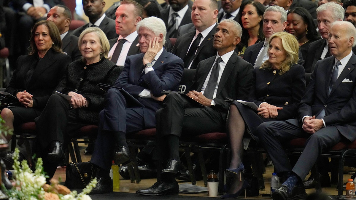 Former Vice President Kamala Harris, former Secretary of State Hillary Clinton, former Presidents Bill Clinton, Barack Obama, and Joe Biden, and former first lady Jill Biden seated in a row.