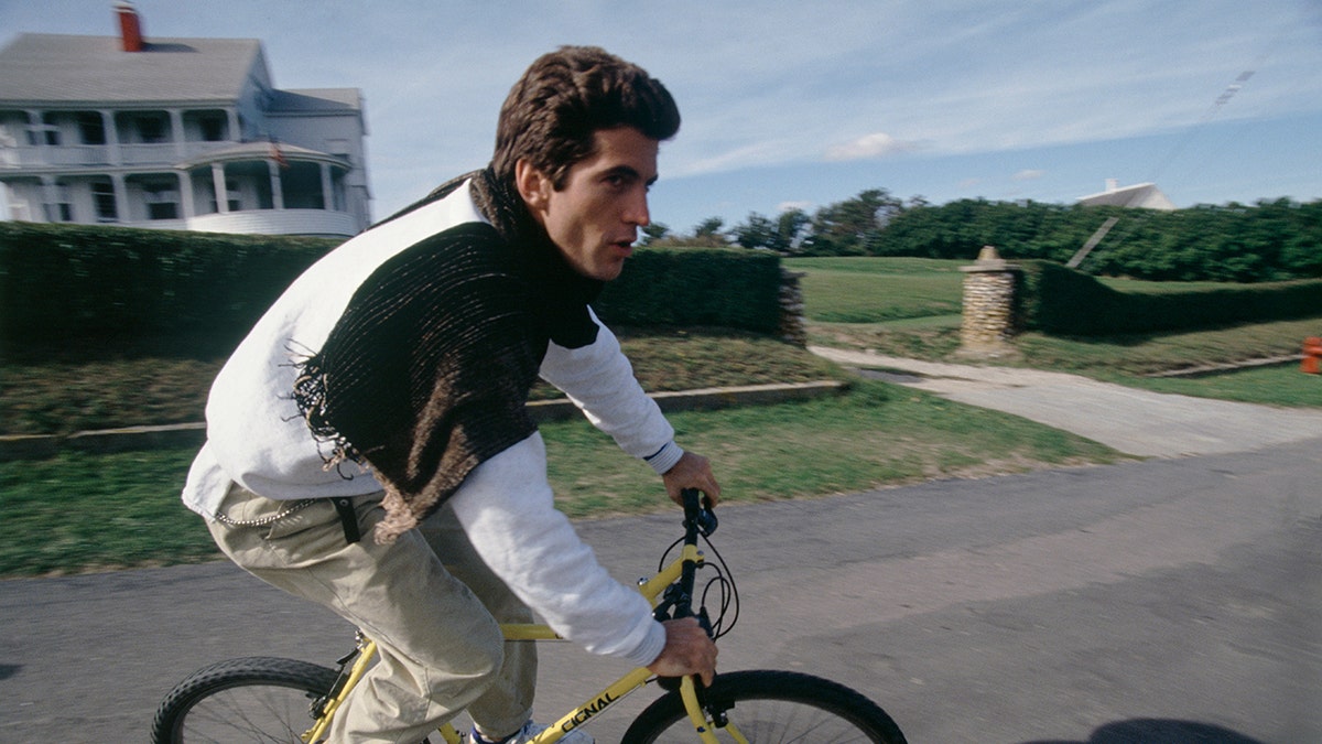 John F. Kennedy Jr. riding a bike.