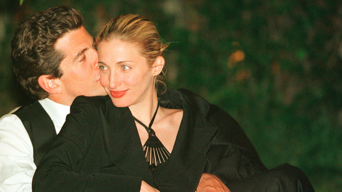 John F. Kennedy Jr. kissing Carolyn Bessette Kennedy on the cheek.