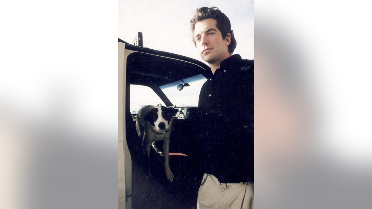 John F. Kennedy Jr. standing with his dog Friday.