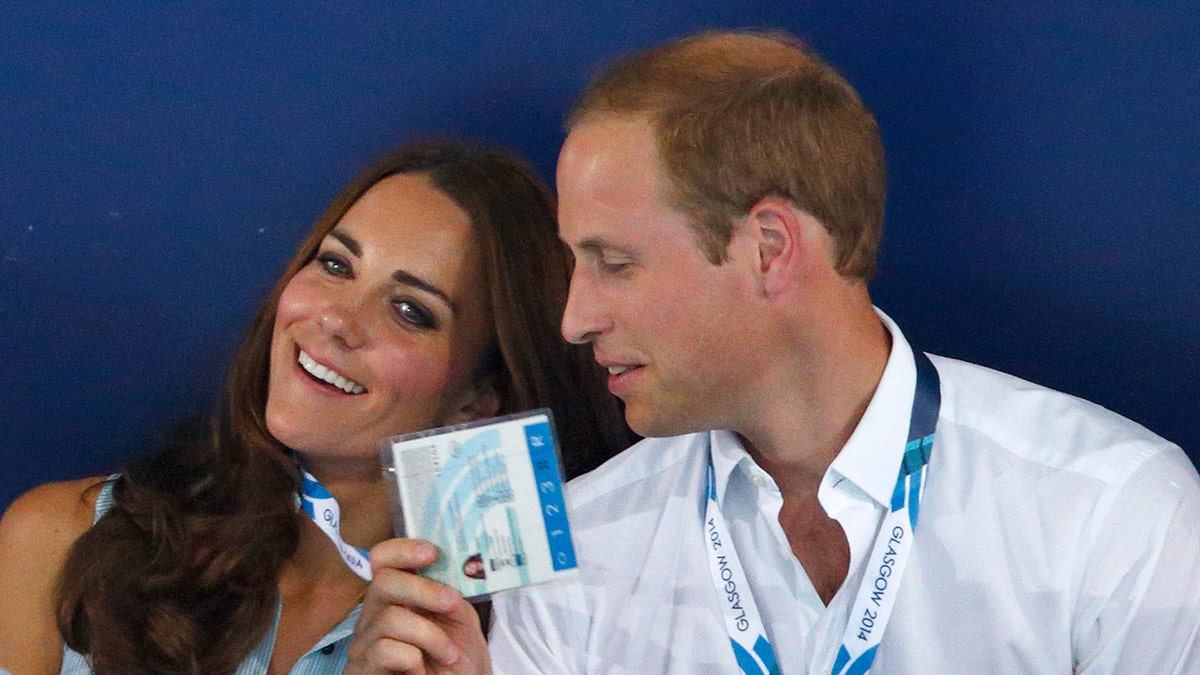 Prince William and Kate Middleton sharing a joking moment while attending a swimming event.
