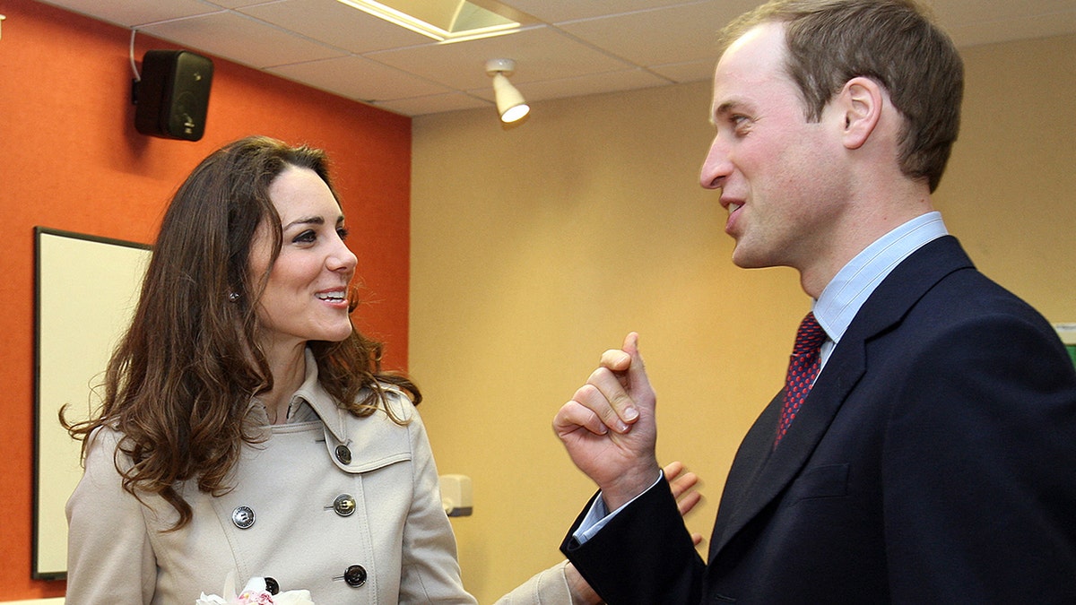 Kate Middleton and Prince William smiling and admiring each other mid conversation.