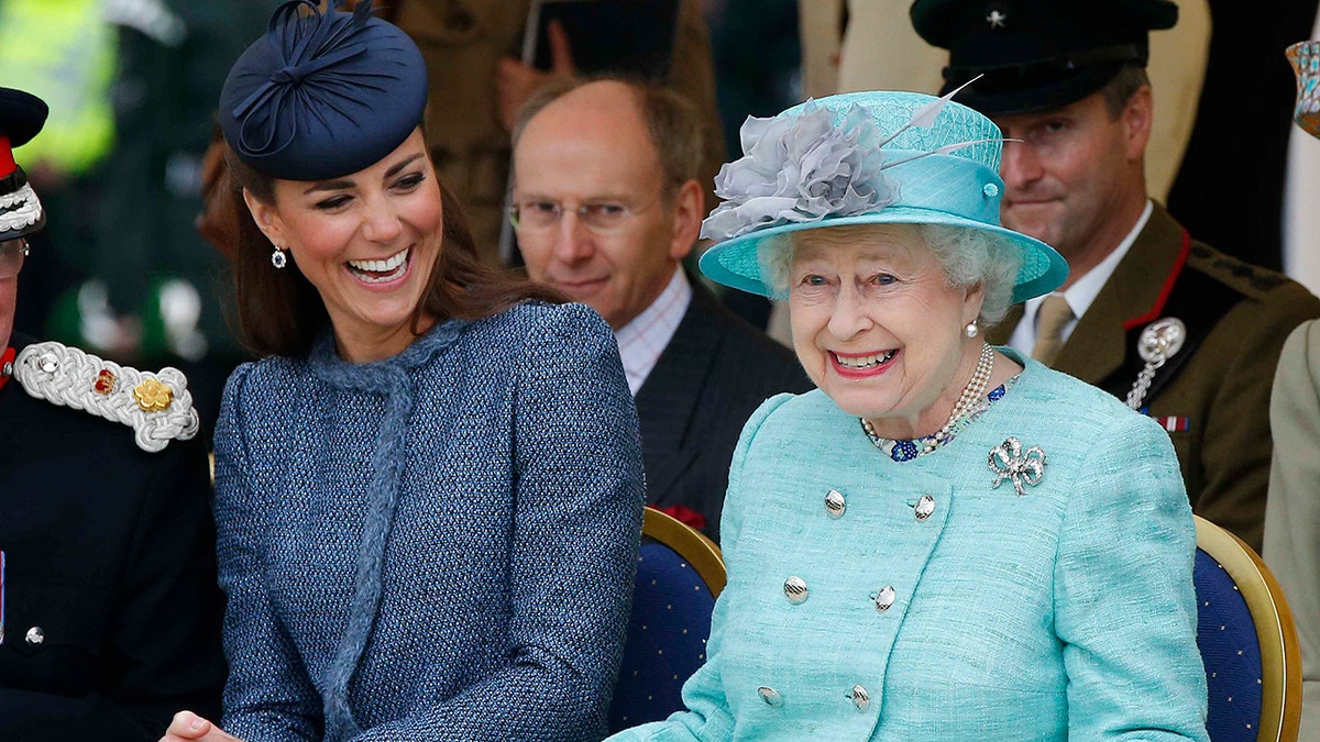 Queen Elizabeth II and Kate Middleton sharing a laugh at a royal engagement.