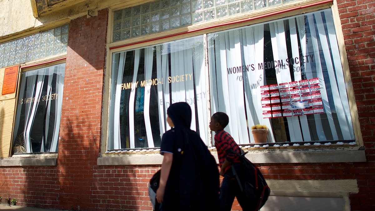 People walk outside Kermit Gosnell's clinic in West Philadelphia