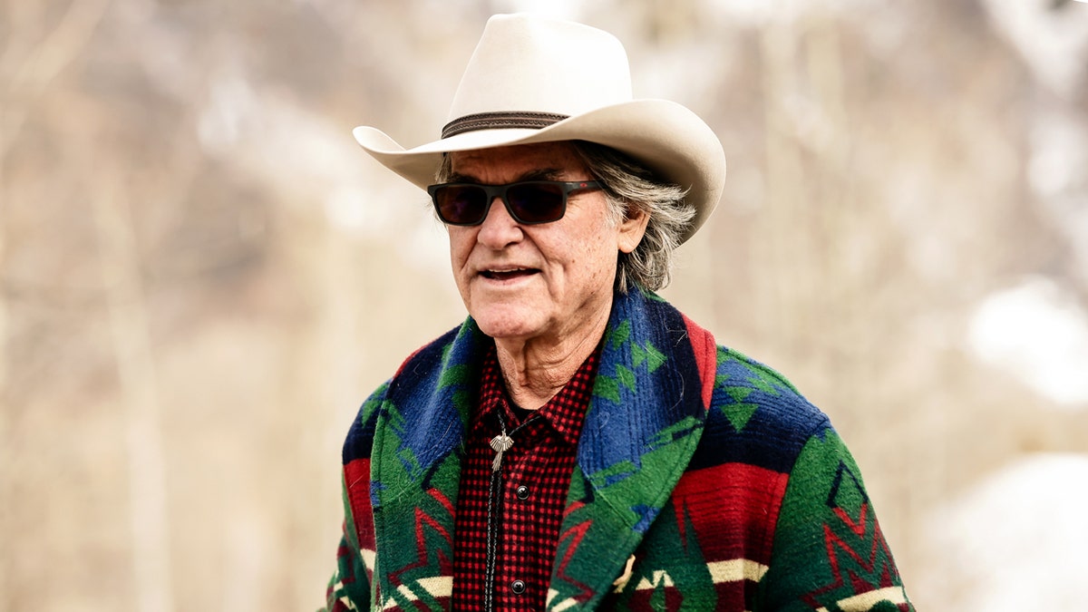 Kurt Russell wears a cowboy hat and sunglasses