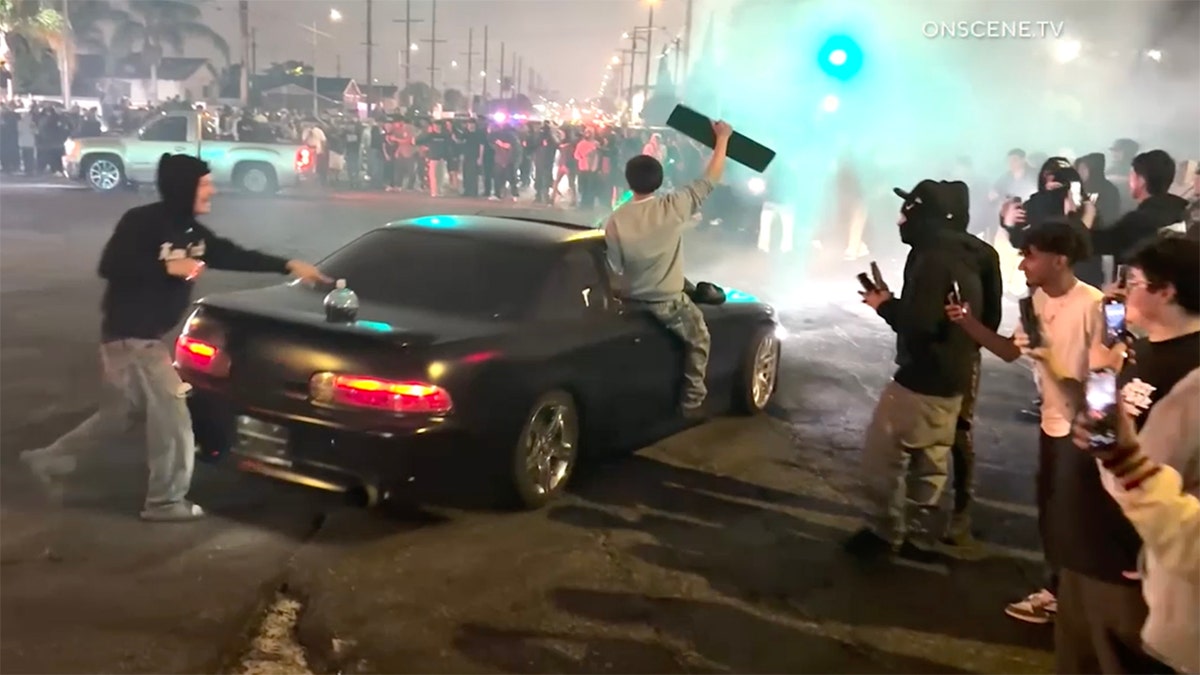 black sedan doing donuts thoroughfare  takeover