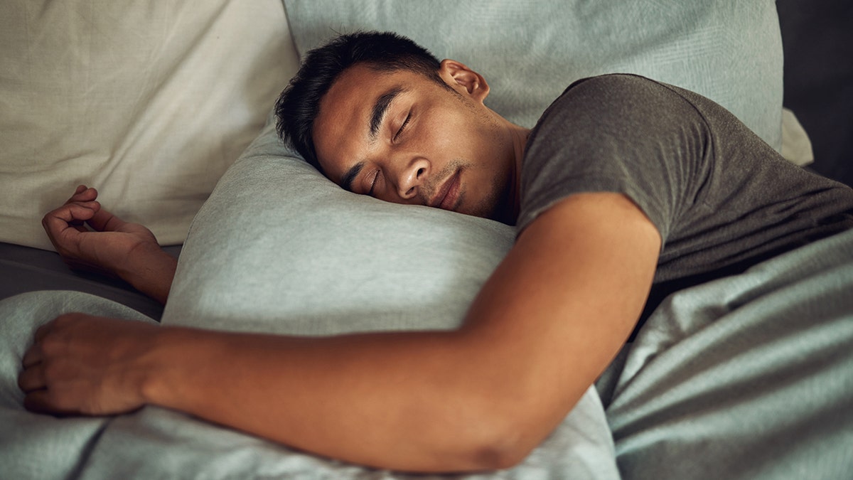 man sleeping soundly in bed on pillow
