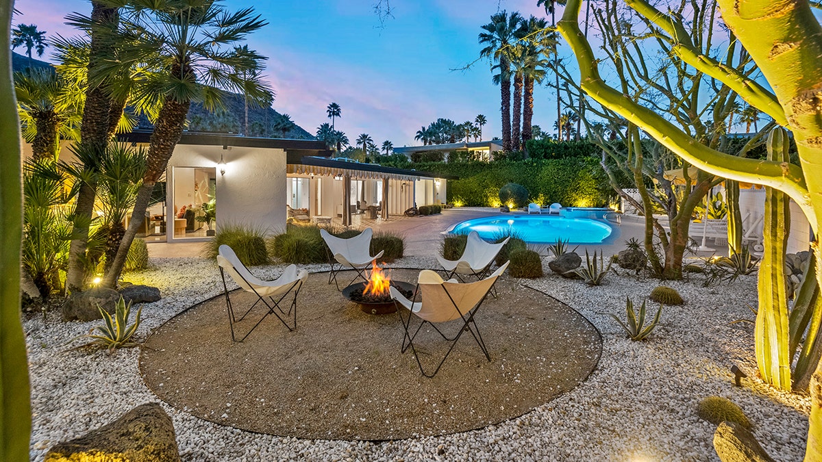 The backyard features a fire pit next to the pool.