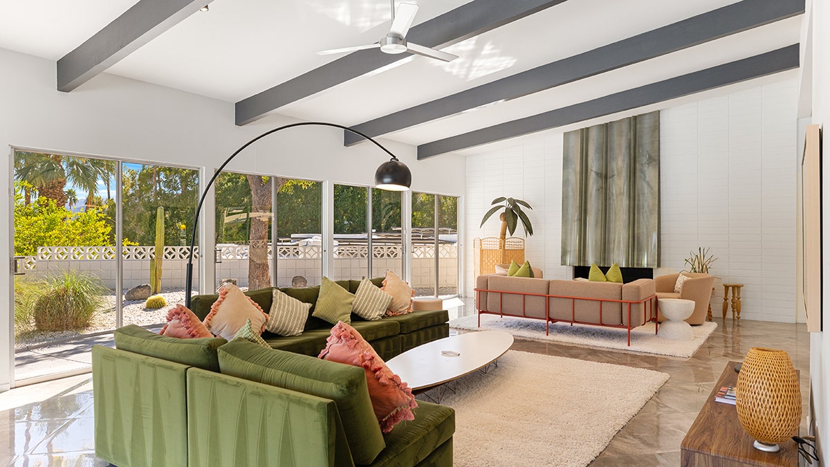 The living room features gray beams on the ceiling and a fireplace.
