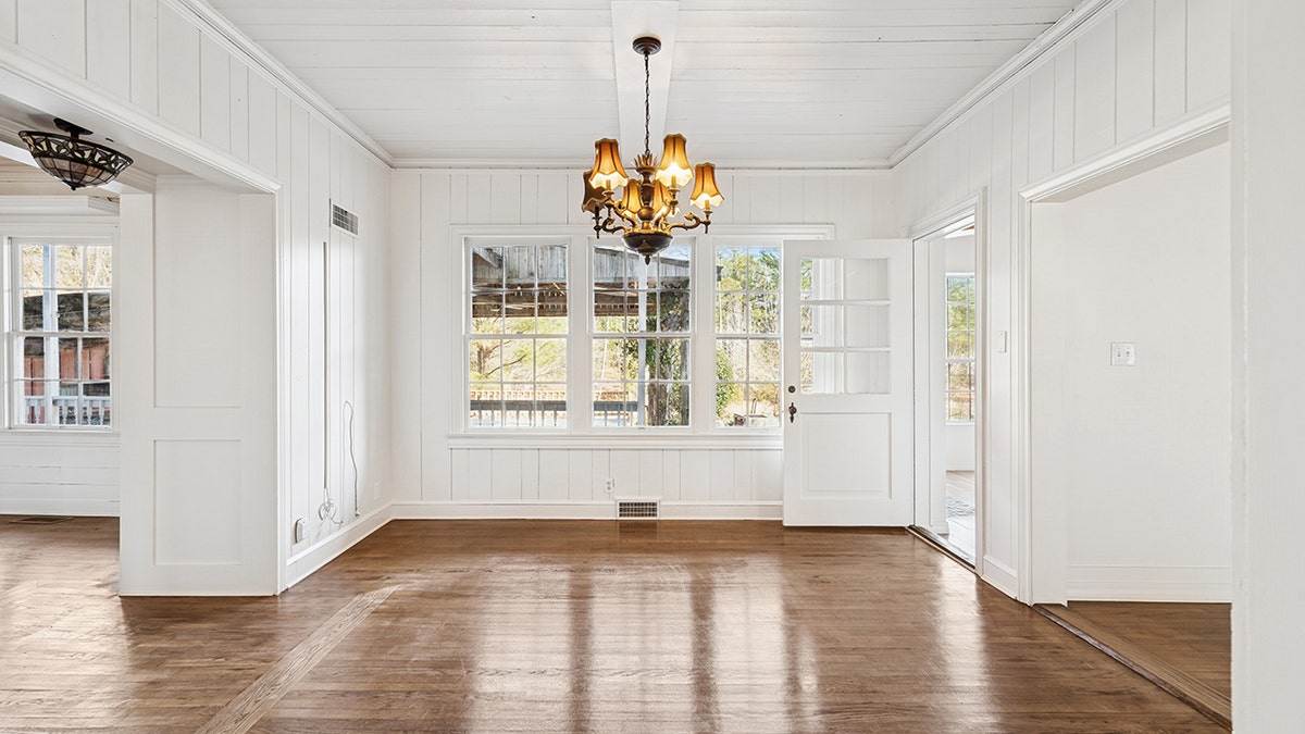 An empty room with hardwood floors and white walls.