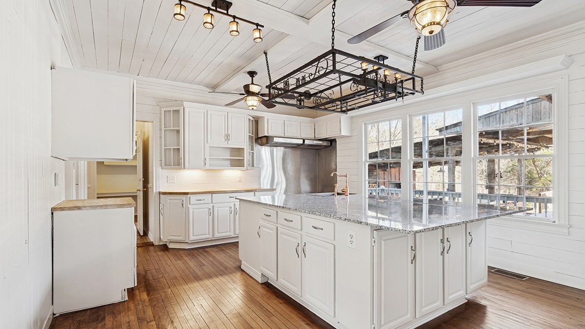 The kitchen features a large center island with a unique light fixture hanging above it.