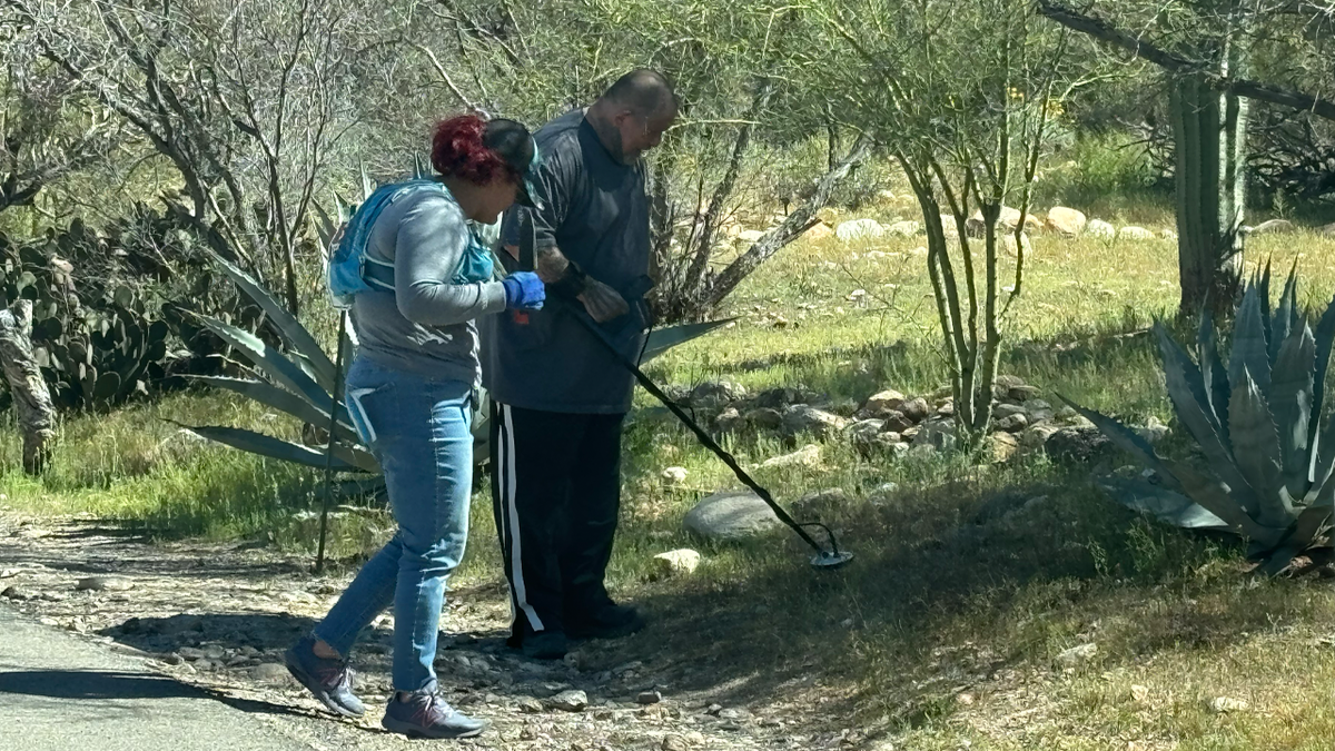 Alex Zabel operates a metal detector at Nancy Guthrie's house.