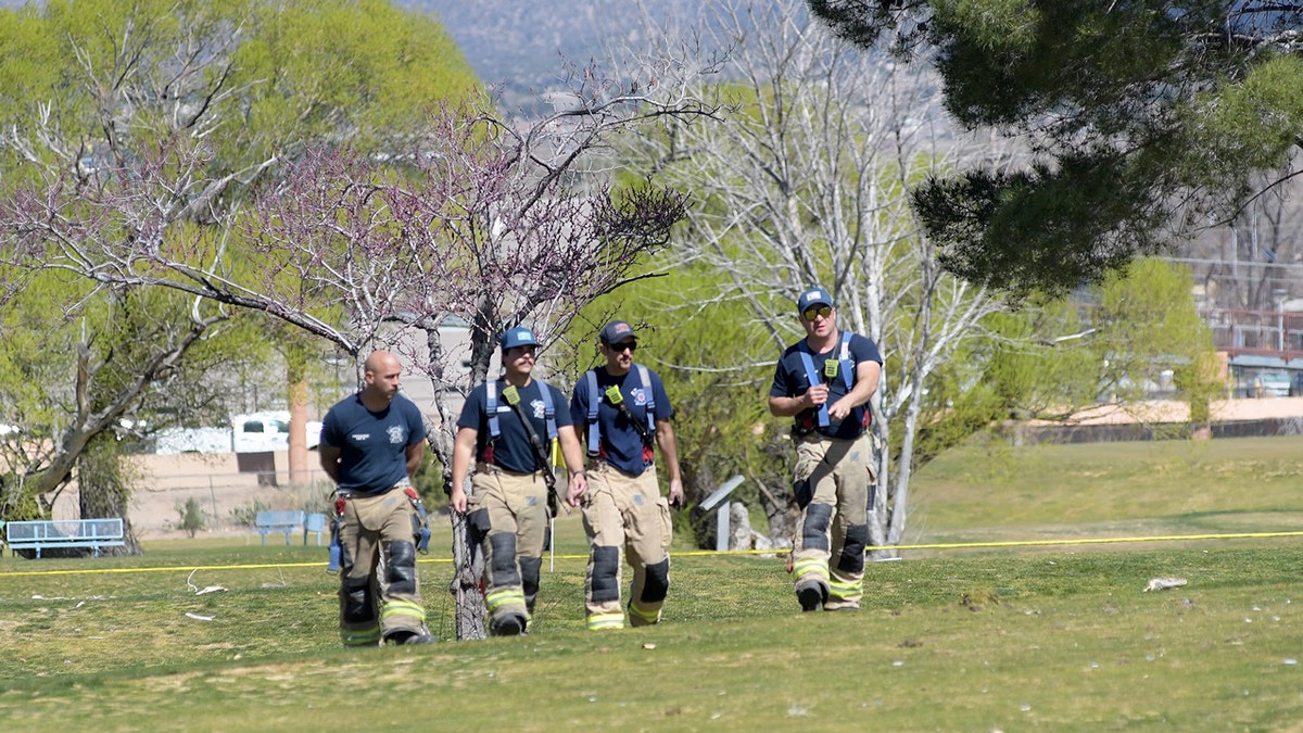 Firefighters walking in a grass field