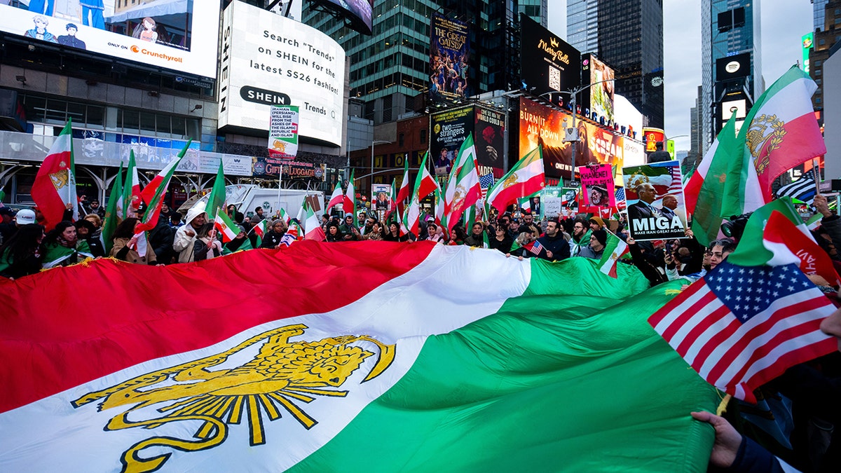 People waving a large Iranian flag in Times Square.