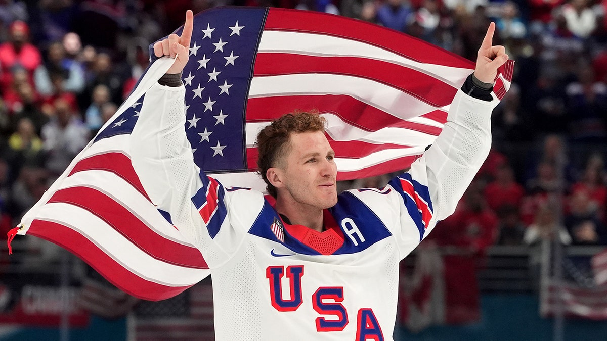 Matthew Tkachuk holds the American flag