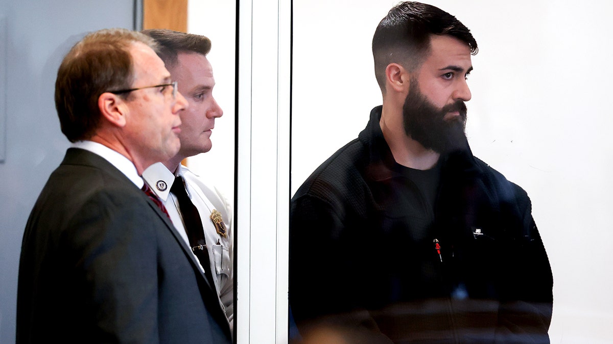 Nicholas O'Malley stands next to lawyer in court