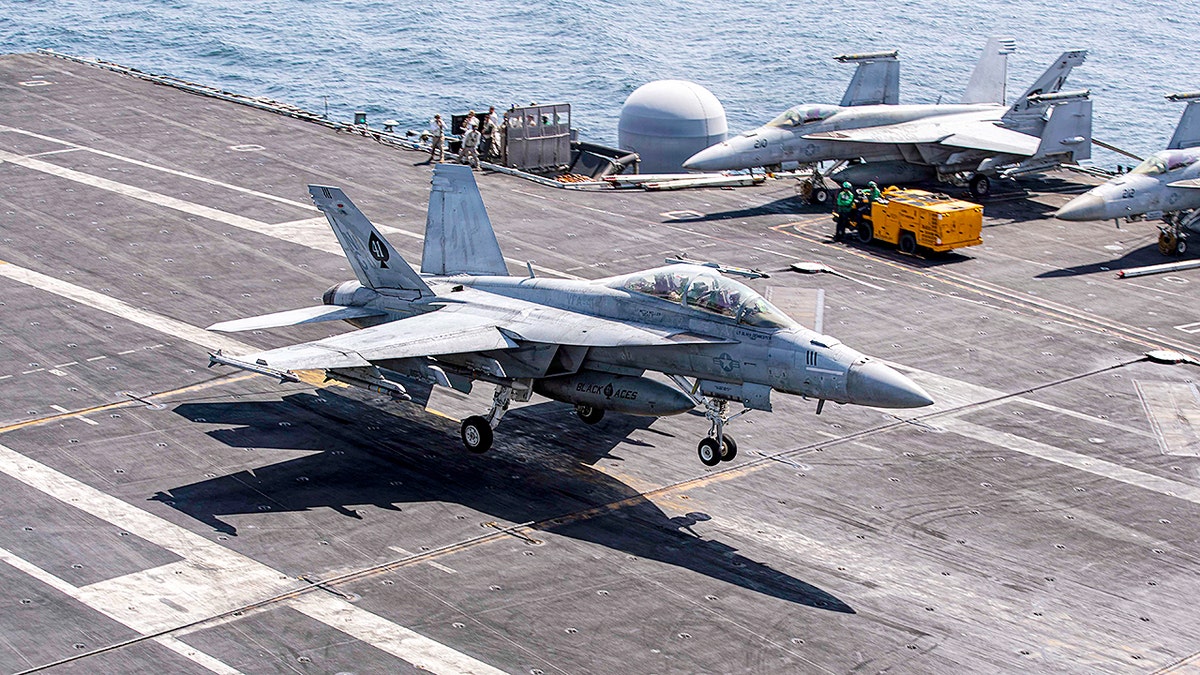 An F/A-18F Super Hornet aircraft making an arrested landing on the flight deck of the USS Abraham Lincoln.