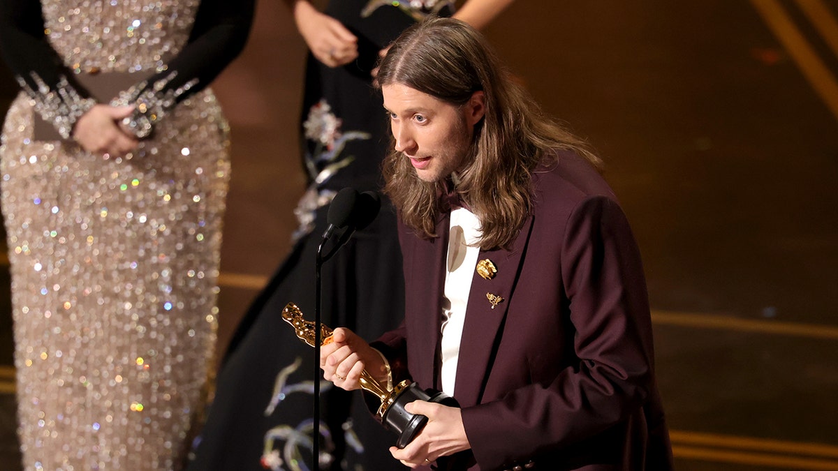 Ludwig Göransson holding an Oscar award while standing on a stage.