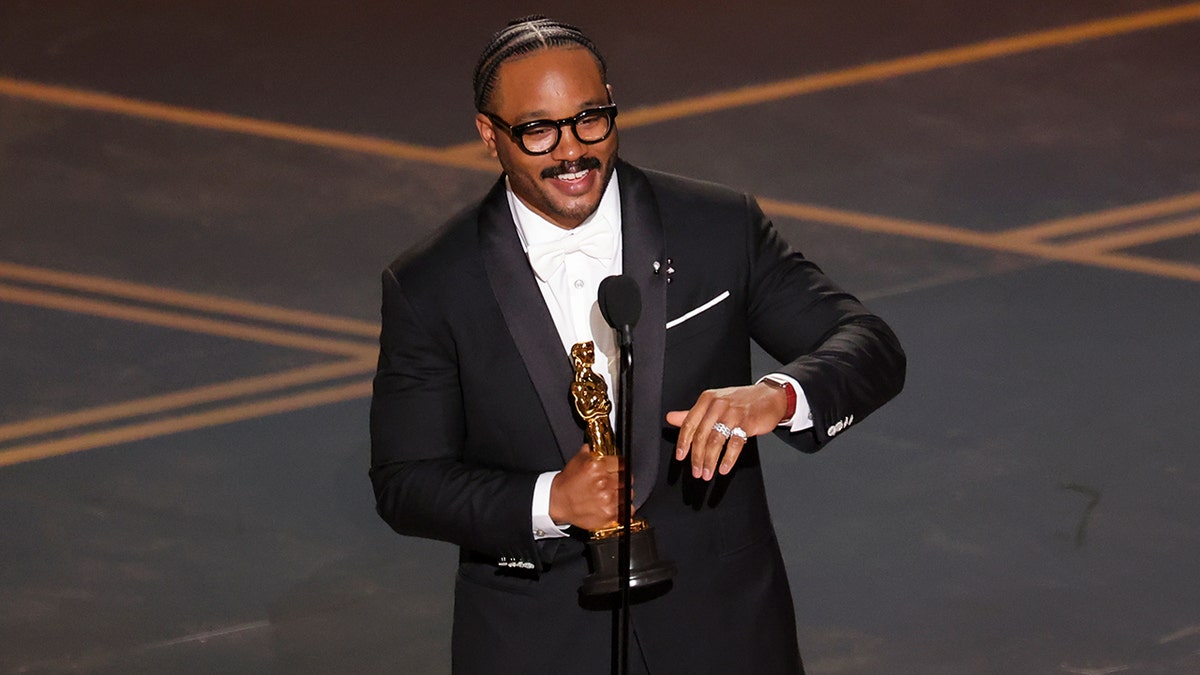 Ryan Coogler holding an Oscar statuette at the 98th Annual Oscars.