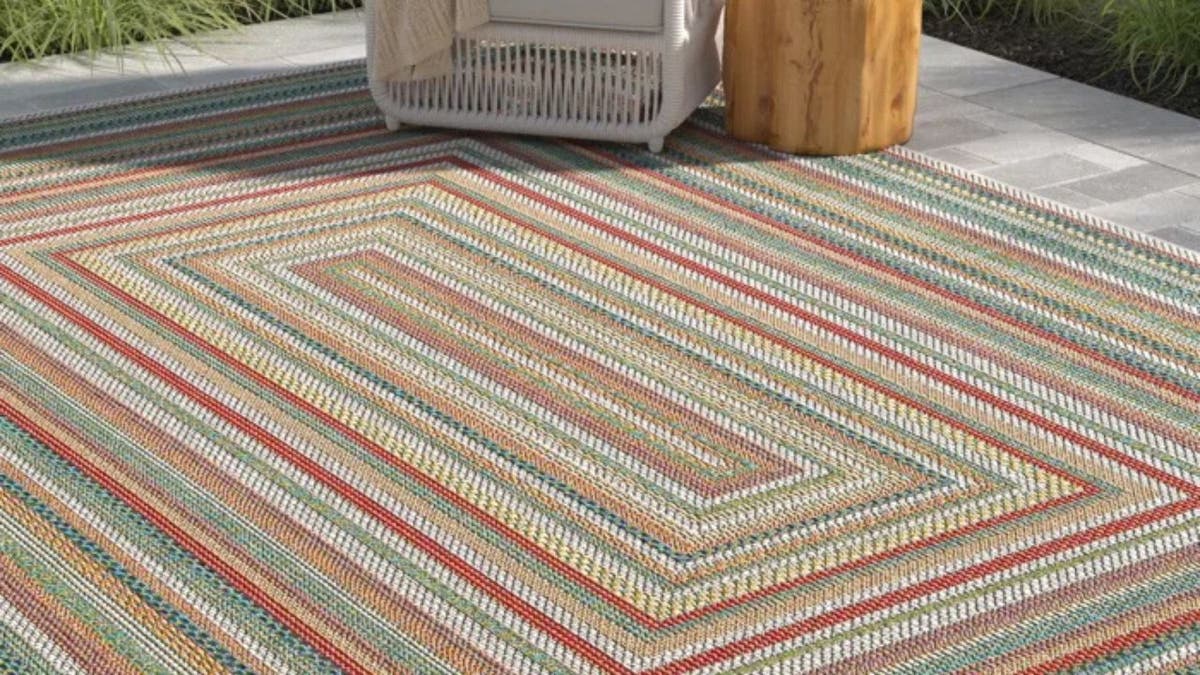 Add interest to a bare patio with a big rug.